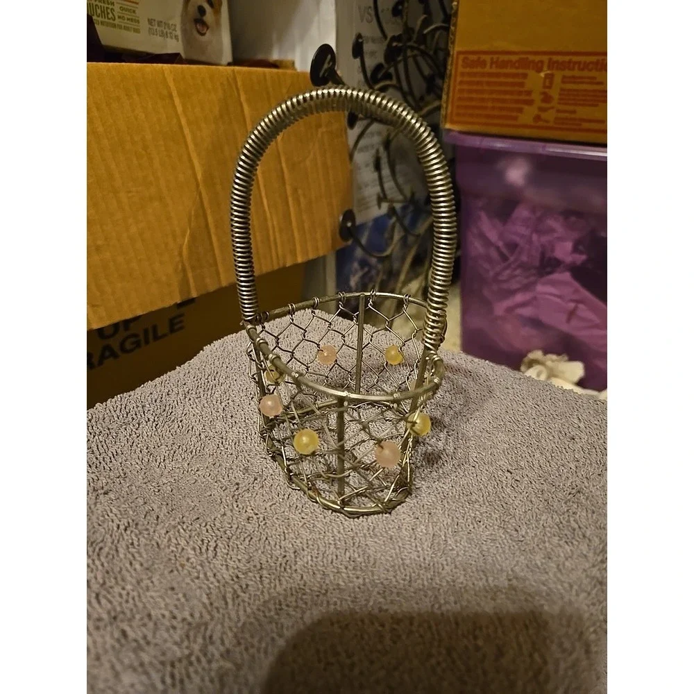 silver-tone wire basket featuring a heart-shaped base and a coiled wire handle